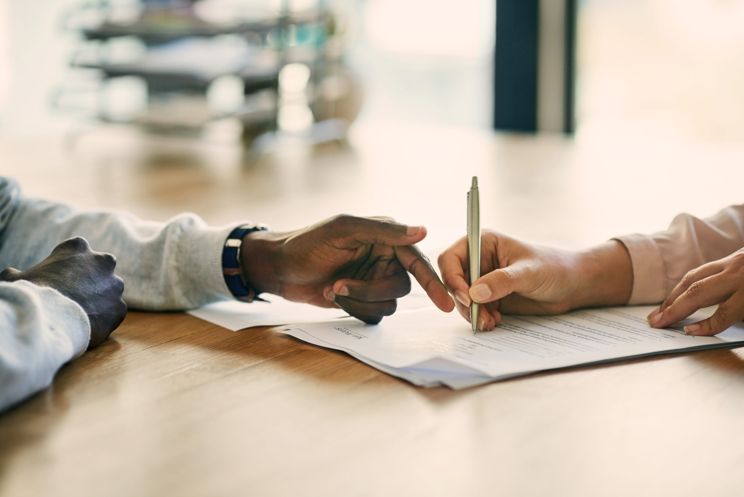 Closeup shot of two businesspeople filling in paperwork in an office